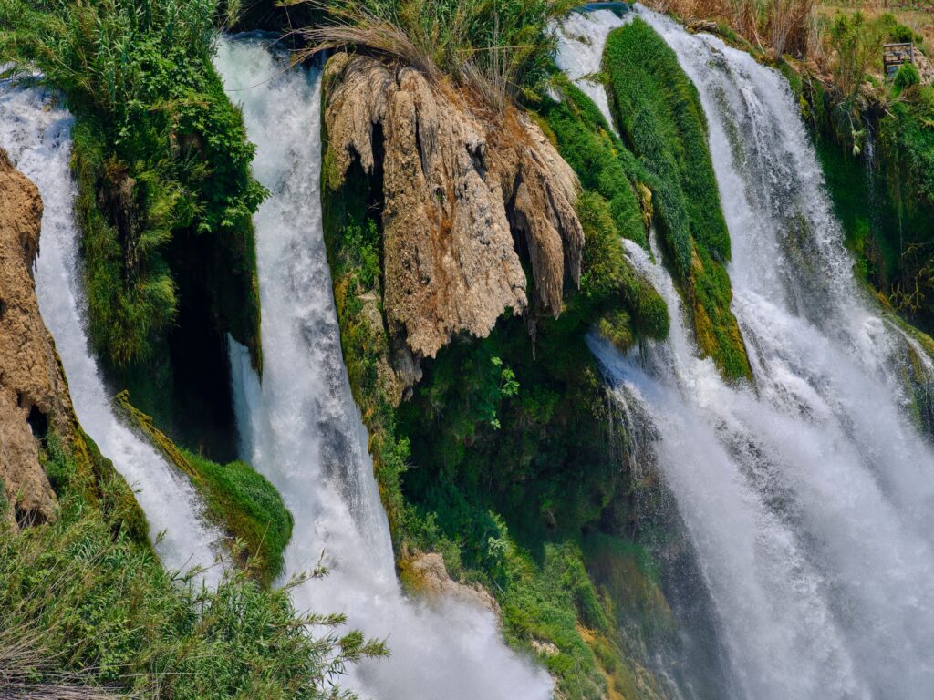 A beautiful waterfall cascading over mossy rocks in a lush forest setting, showcasing nature's tranquility.
